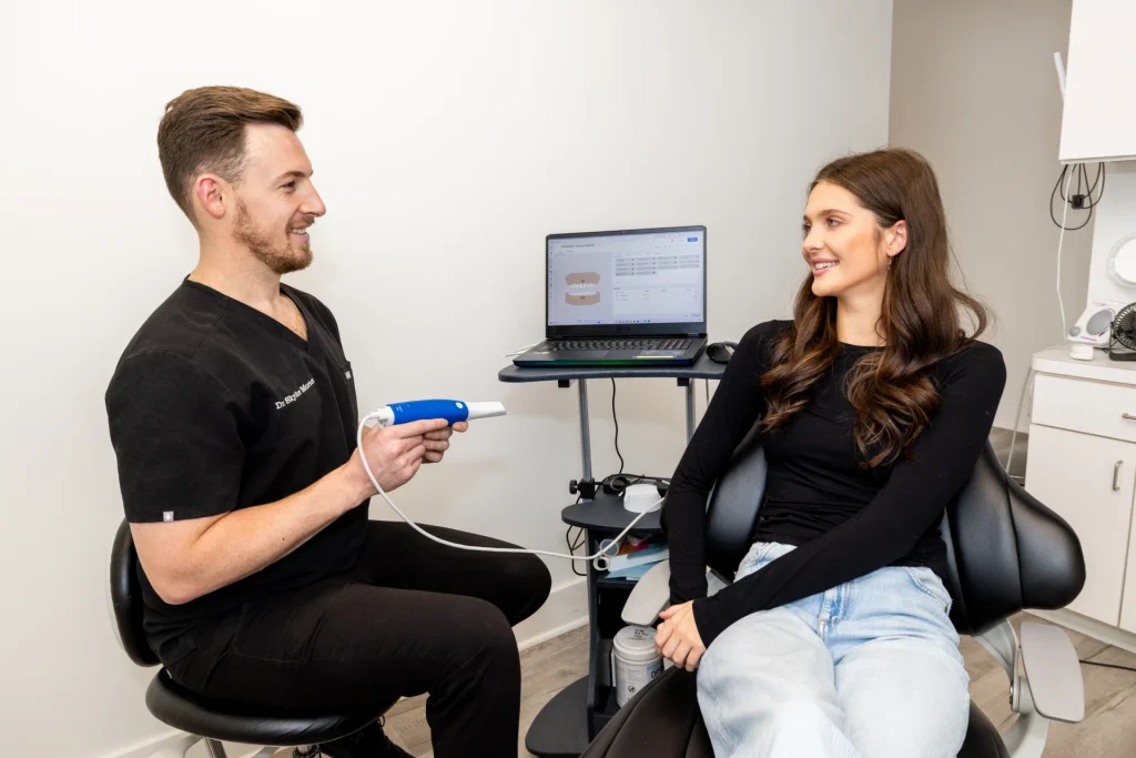 Dr. Morton showing a patient the intra-oral scanner